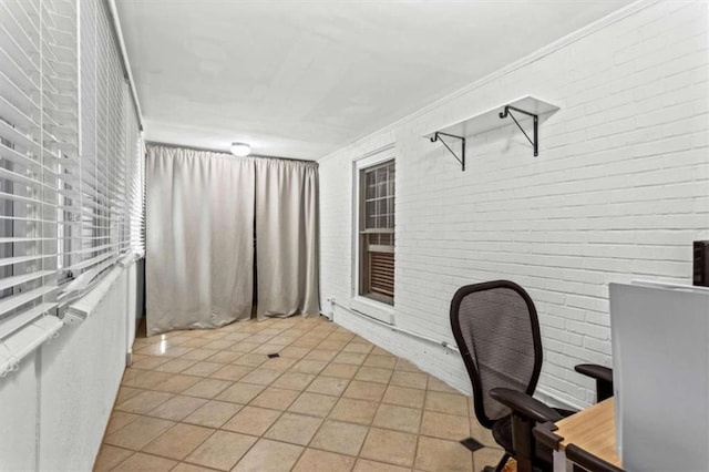 unfurnished office with light tile patterned floors and brick wall