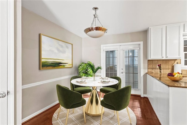 dining area featuring dark wood-type flooring and baseboards