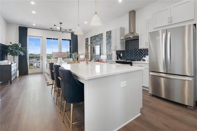 989 Bibbs Cir NW Unit 25, Atlanta, GA 30318 - kitchen with stainless steel appliances, wall chimney exhaust hood, recessed lighting, light countertops, and a center island with sink