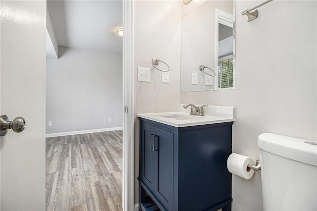 bathroom featuring vanity, baseboards, toilet, and wood finished floors