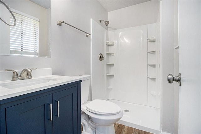 full bath featuring vanity, toilet, a shower, and wood finished floors