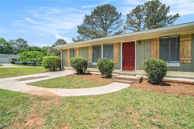 ranch-style house featuring board and batten siding, concrete driveway, and a front yard