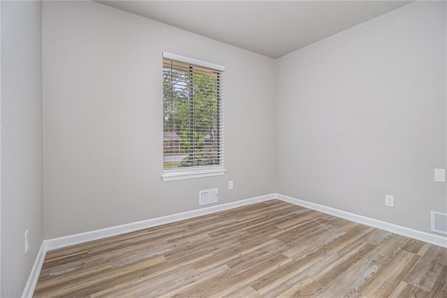 unfurnished room with baseboards and light wood finished floors