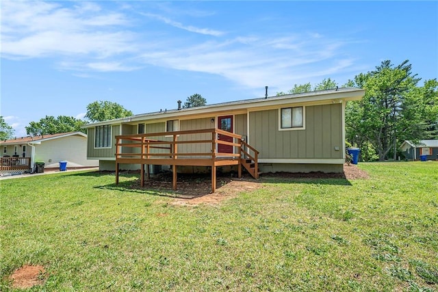 rear view of house with a yard and a deck