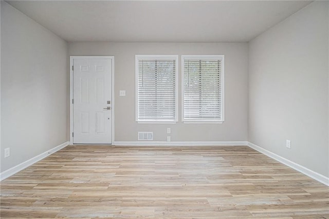 unfurnished room with baseboards, visible vents, and light wood-style floors