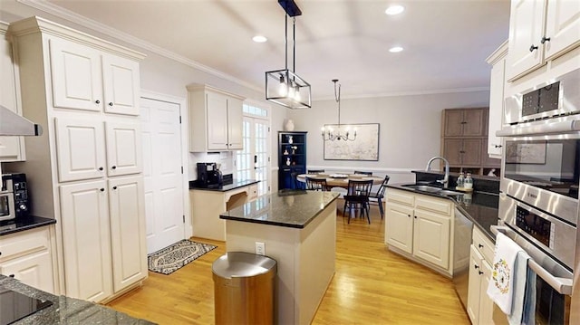 kitchen featuring a sink, crown molding, recessed lighting, appliances with stainless steel finishes, and light wood-style floors