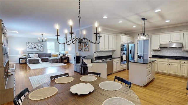 kitchen with under cabinet range hood, stainless steel appliances, recessed lighting, dark countertops, and backsplash