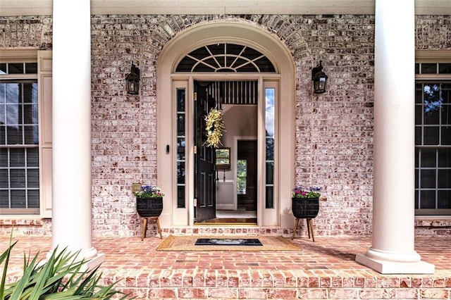 property entrance with brick siding and covered porch