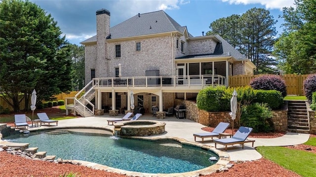 back of house featuring stairway, a patio, a chimney, and a deck