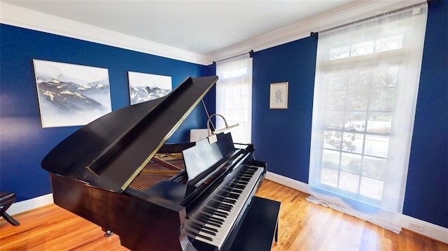living area featuring ornamental molding, baseboards, and wood finished floors