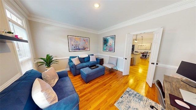 living area featuring light wood-style flooring, crown molding, and baseboards