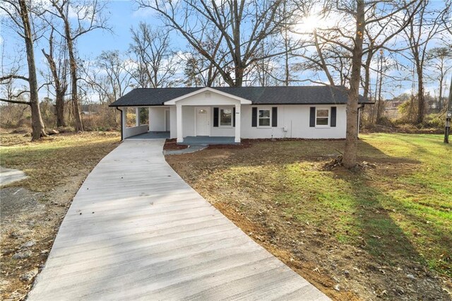 single story home with a carport, covered porch, and a front yard