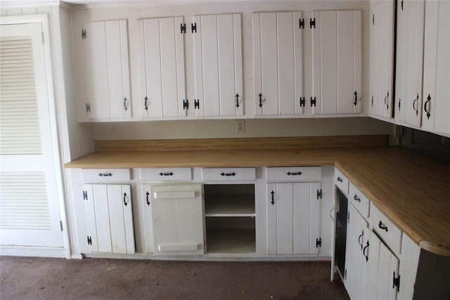 interior space featuring white cabinets and dark carpet