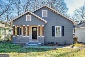 bungalow-style house with a front yard and covered porch