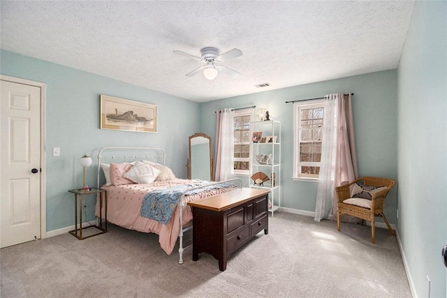 carpeted bedroom featuring ceiling fan and a textured ceiling