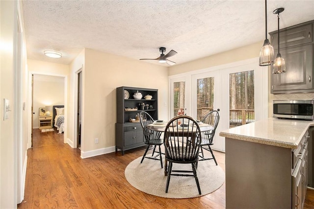 dining space featuring dark hardwood / wood-style flooring, ceiling fan, french doors, and a textured ceiling