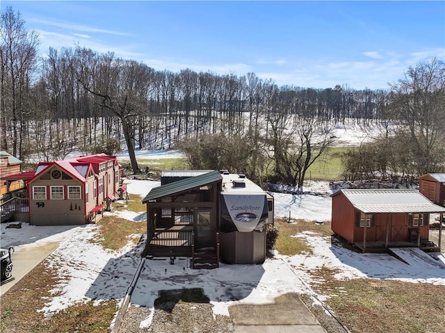 yard covered in snow with an outbuilding