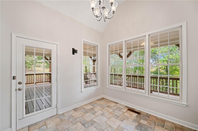 interior space featuring visible vents, lofted ceiling, stone tile floors, an inviting chandelier, and baseboards