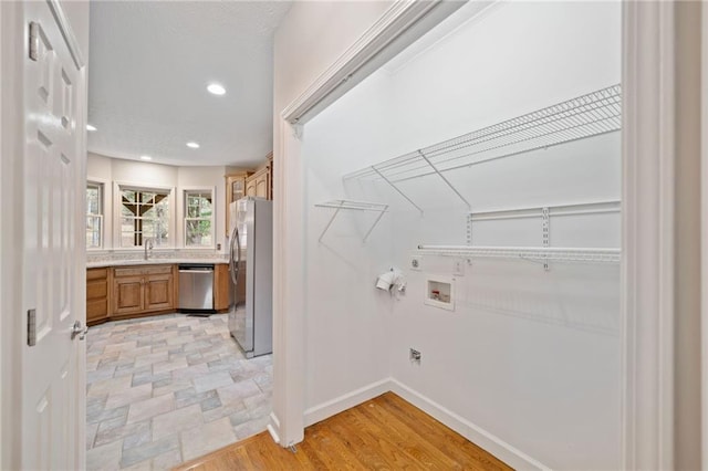 laundry area featuring baseboards, washer hookup, laundry area, recessed lighting, and light wood-style floors