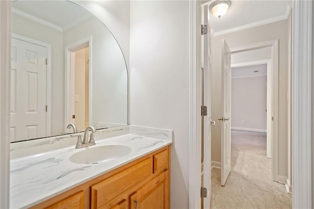 bathroom featuring vanity, crown molding, and baseboards