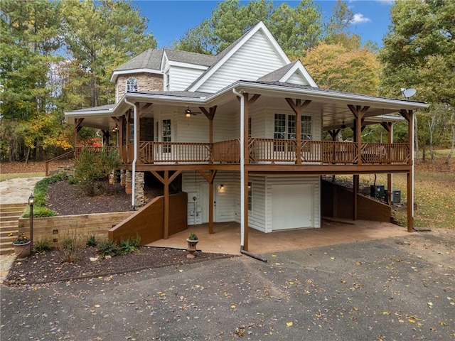 country-style home with a garage, covered porch, stairs, and a shingled roof