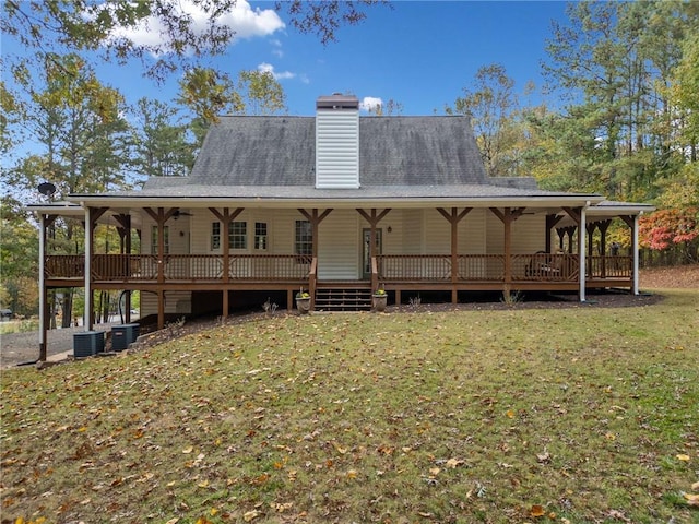 back of property with cooling unit, a lawn, and a chimney