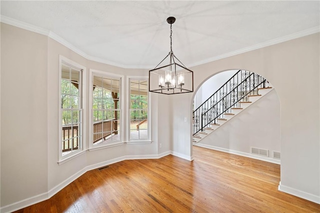 unfurnished dining area featuring visible vents, baseboards, wood finished floors, and stairway