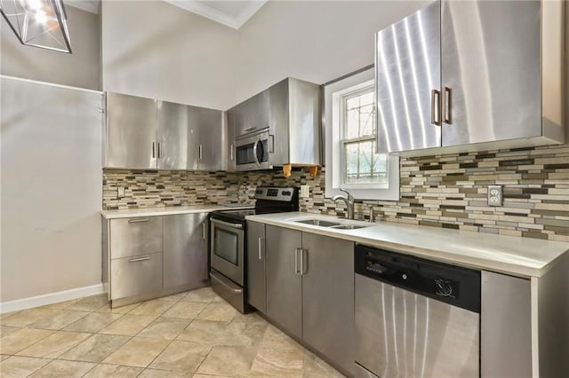 kitchen featuring tasteful backsplash, ornamental molding, appliances with stainless steel finishes, and sink