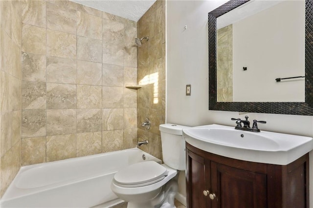 full bathroom featuring vanity, tiled shower / bath, and toilet