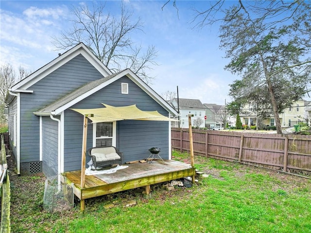 rear view of house featuring a yard and a deck