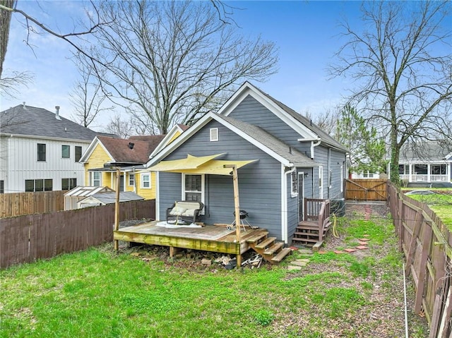 back of house with a deck and a lawn