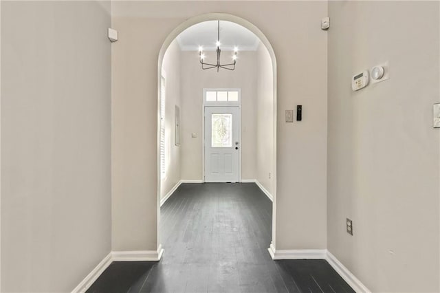 foyer entrance with dark wood-type flooring and a notable chandelier