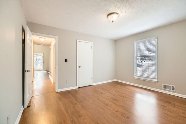 unfurnished bedroom with a textured ceiling and light hardwood / wood-style floors