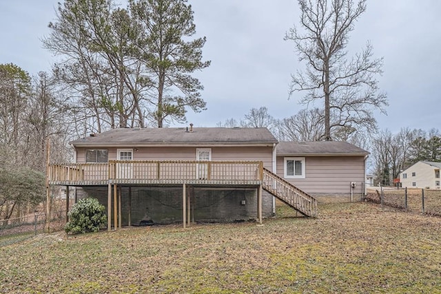 rear view of house with a wooden deck and a yard