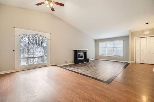 unfurnished living room featuring hardwood / wood-style floors, vaulted ceiling, and ceiling fan