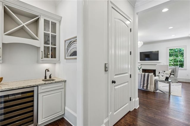 3113 Lenox Rd NE Unit 6, Atlanta, GA 30324 - indoor wet bar featuring beverage cooler, dark wood-style floors, baseboards, recessed lighting, and ornamental molding