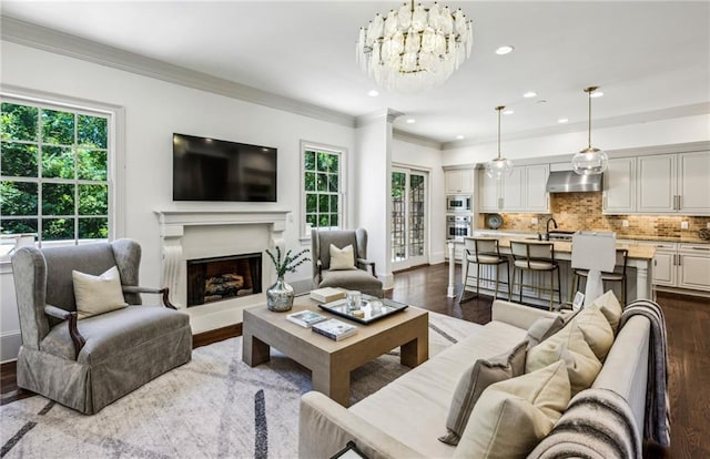 3113 Lenox Rd NE Unit 6, Atlanta, GA 30324 - living room with dark wood-style floors, a chandelier, ornamental molding, a fireplace with raised hearth, and recessed lighting