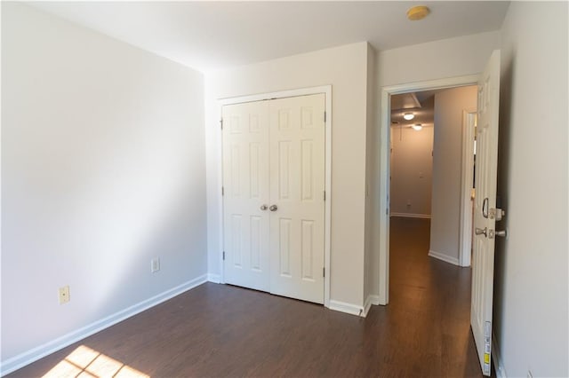 unfurnished bedroom featuring a closet and dark hardwood / wood-style flooring