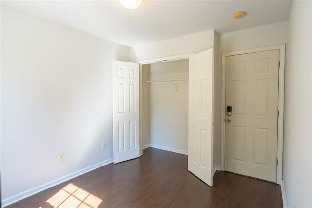 unfurnished bedroom featuring a closet and dark hardwood / wood-style floors