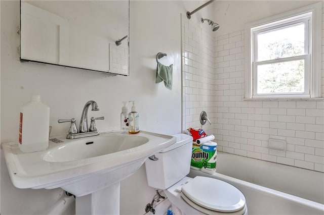 full bathroom with tiled shower / bath combo, toilet, and sink