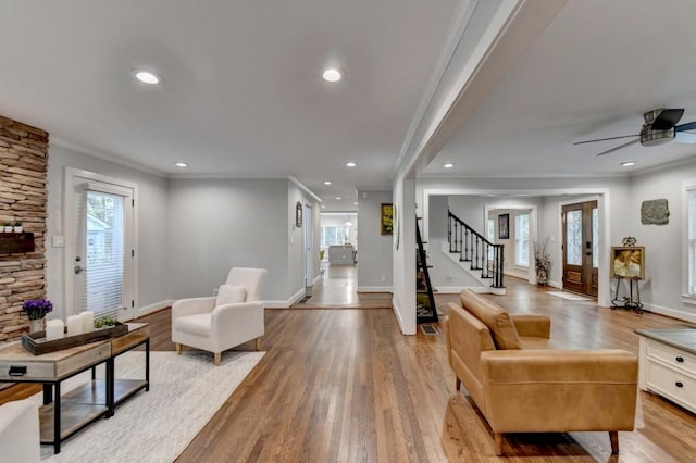 living area with stairway, recessed lighting, light wood-type flooring, and ornamental molding