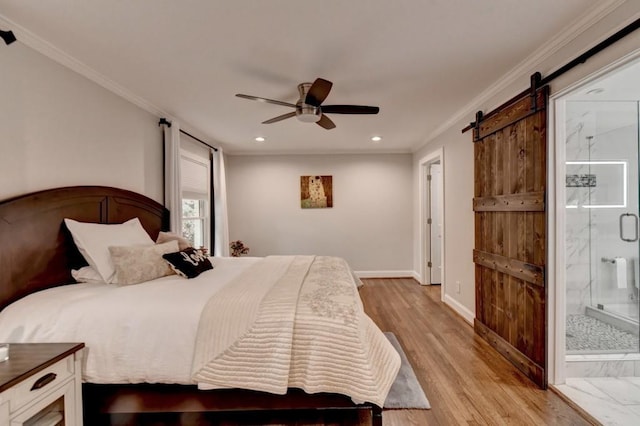 bedroom with baseboards, ornamental molding, light wood-style floors, ensuite bathroom, and a barn door