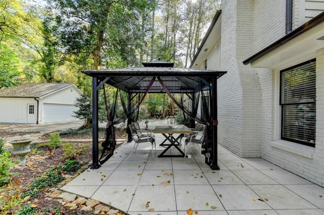 view of patio / terrace featuring a gazebo, outdoor dining area, and an outbuilding