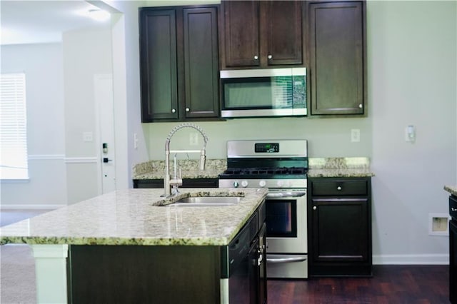 4417 Belcamp Rd, Fairburn, GA 30213 - kitchen with stainless steel appliances, dark wood-style flooring, light stone counters, a center island with sink, and dark brown cabinetry