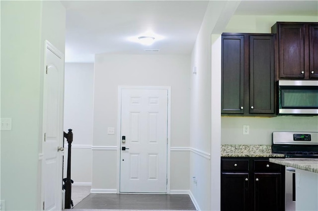 4417 Belcamp Rd, Fairburn, GA 30213 - kitchen with appliances with stainless steel finishes, light stone counters, dark brown cabinets, and wood finished floors