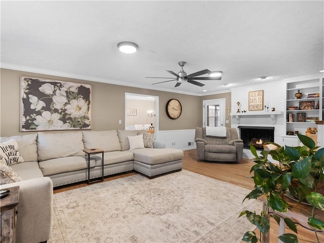 living room featuring hardwood / wood-style flooring, ornamental molding, and ceiling fan