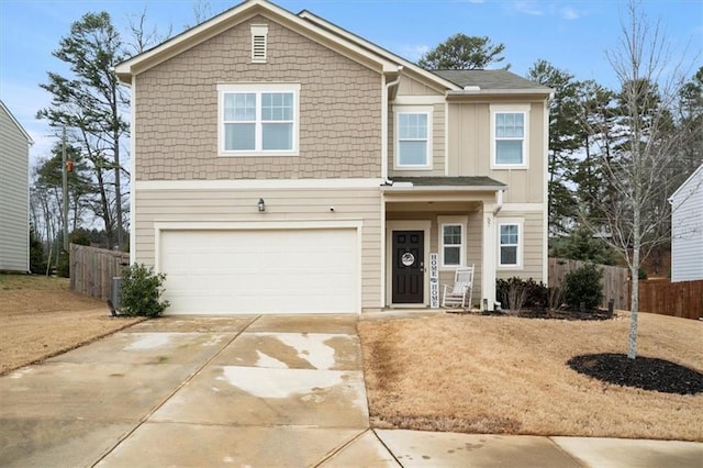 traditional home with concrete driveway, an attached garage, and fence