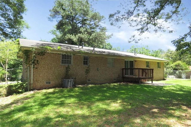 rear view of house with cooling unit and a yard