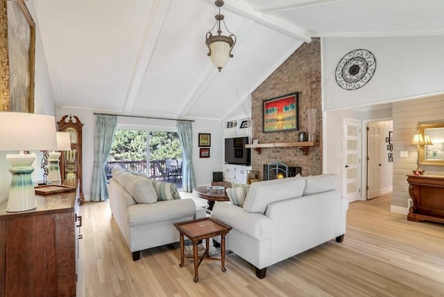 living room with light hardwood / wood-style flooring, a fireplace, high vaulted ceiling, wooden walls, and beamed ceiling