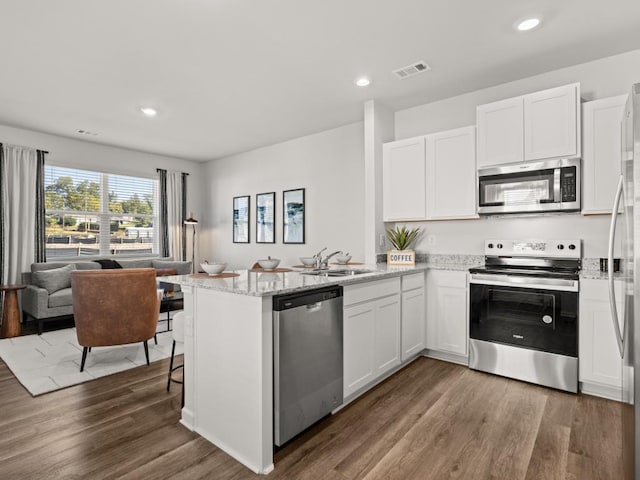 kitchen featuring white cabinets, kitchen peninsula, and stainless steel appliances